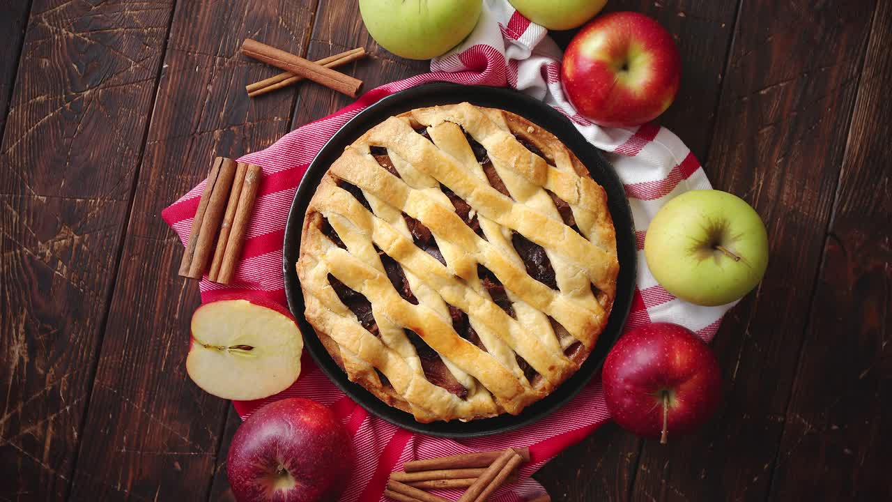 pastel de manzana casero con productos de panadería en la mesa de la cocina de madera oscura