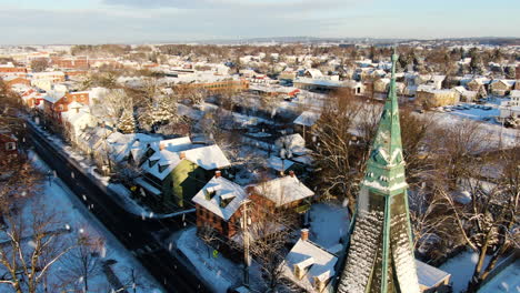 aerial flyby close up of old church spire in winter snow