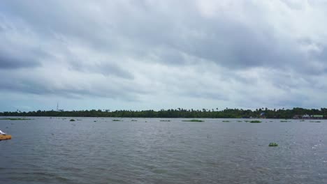 A-look-at-the-special-kind-of-sky-found-in-places-like-India-and-Sri-Lanka,-The-sky-is-ready-to-rain,-very-dramatic-sky-,Panning-shot-over-the-houseboat