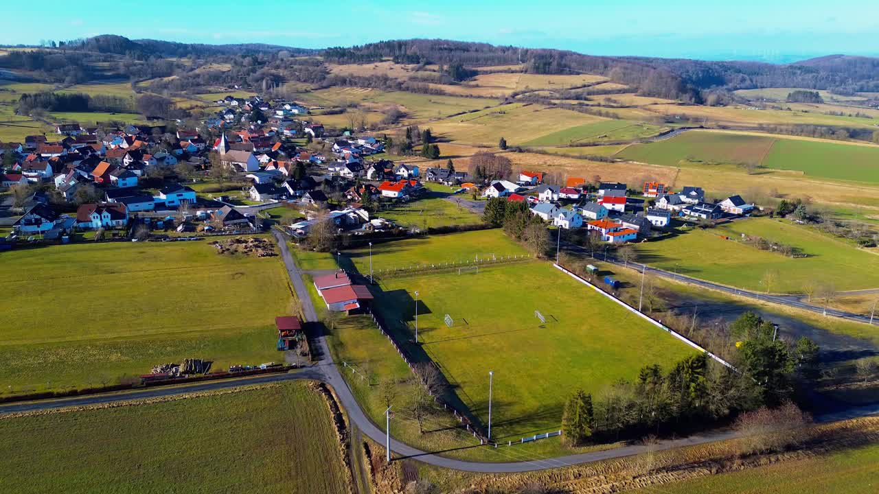 vista elevada de un pueblo vibrante rodeado de exuberantes pastos