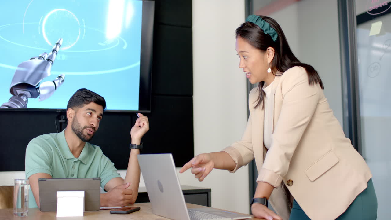Discussing robotic technology, colleagues collaborating with laptop in modern office