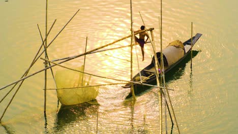 Un-Chico-De-Aldea-Atrapa-Una-Red-De-Pesca-Desde-Un-Barco-En-El-Río-Al-Atardecer