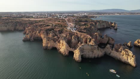 aerial footage from flying drone of tourist yachts on clear blue water in lagos, portugal