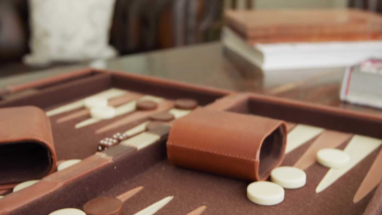 Camera starting on leather backgammon set, slowly panning right, showcasing cozy living room decor