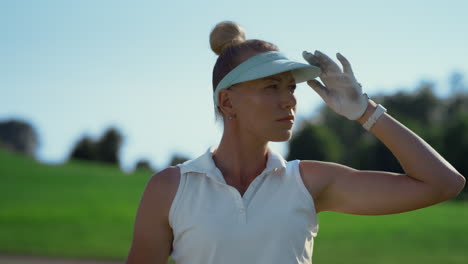 professional golf woman play sport at green fairway. golfer looking in sunlight.