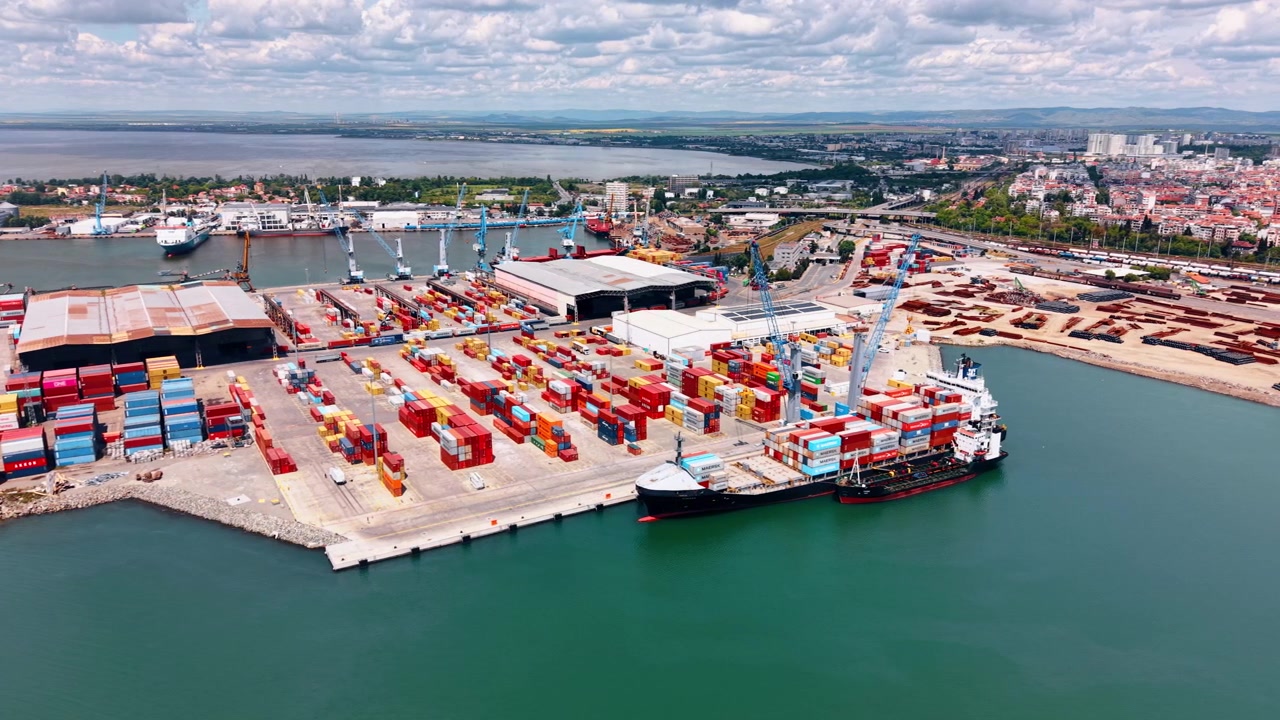 Burgas, Bulgaria, 10 April 2026: Container terminal with docked ship at Burgas port, Bulgaria. Elevated drone shot of colorful cargo rows, warehouses and cranes along the quay.