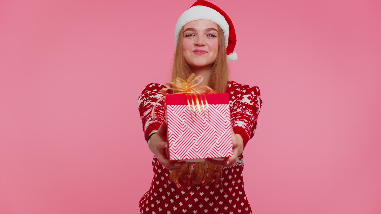 Joyful girl in red christmas sweater with deers presenting christmas gift box shopping holiday sale