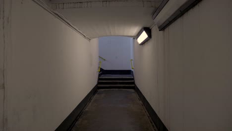 a tight hallway with the lights on in the train station located in northern ireland. -wide shot