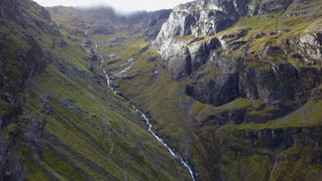 steep whitewater creek runs down steep craggy mountain highland valley