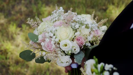 the groom holds a beautiful wedding bouquet, waiting for the bride