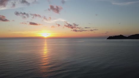 AERIAL:-Drone-flies-High-Above-the-Coastal-Waves-on-the-scenic-Sunset-with-Islands-on-the-Background