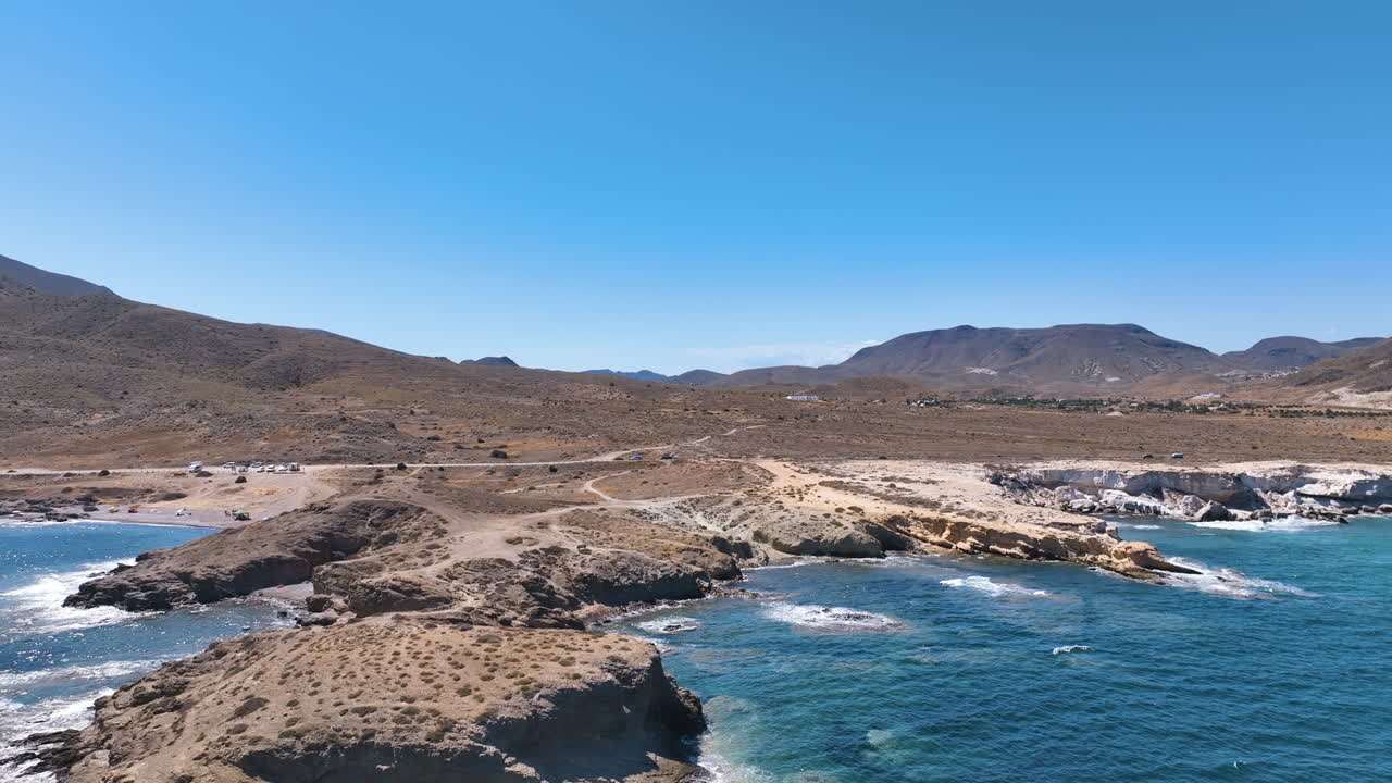 Flight reverses to reveal distinctive eroded volcanic headland and beach Almeria