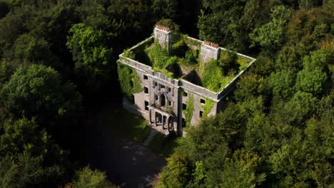 Aerial Orbit of the Ivy-Covered Moore Hall Ruins Hidden in Mayo Forest on a Sunny Day