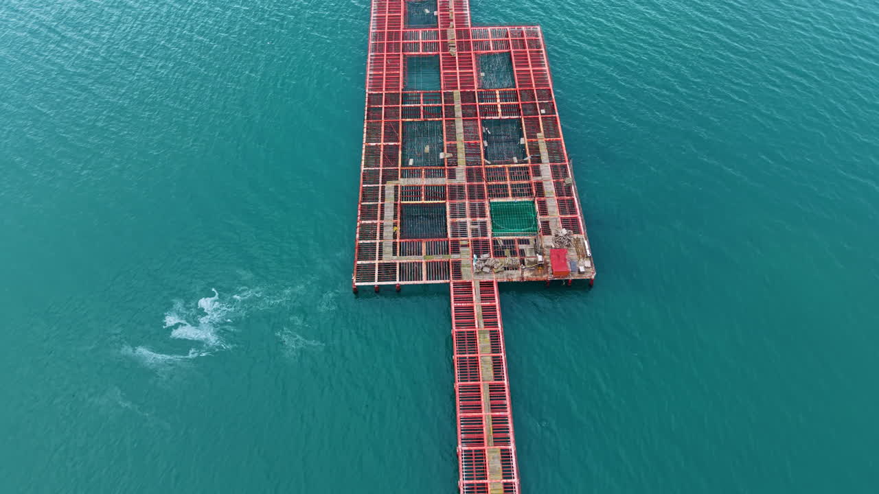 Mussel farm located in the sea with structures for shellfish cultivation and harvesting shown in clear blue water during daytime