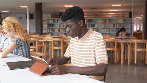 Multiethnic-students-doing-homework-in-library