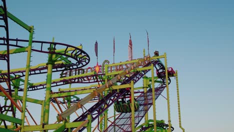 CLOSE-UP:-Cool-shot-of-a-roller-coaster-driving-into-a-twister-on-a-sunny-spring-evening