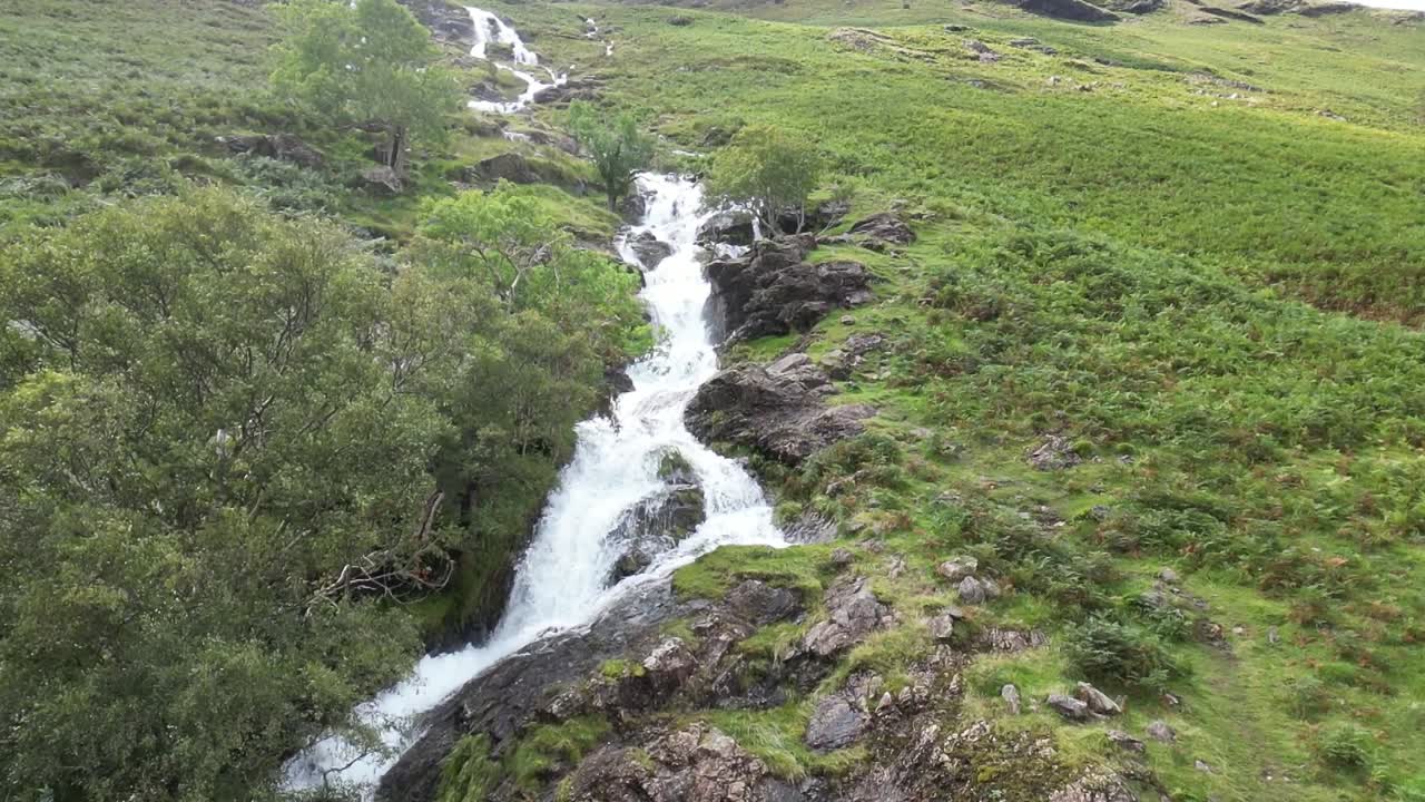 la furiosa cascada que cae en cascada por la montaña es en cámara lenta después de días de fuertes lluvias, dron aéreo parte 4, montaña media baja, buttermere, distrito de los lagos, reino unido