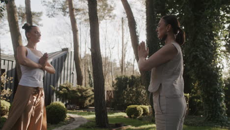 two women practicing yoga in a garden
