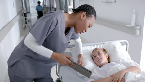 african american nurse assists a caucasian girl in a hospital, with copy space