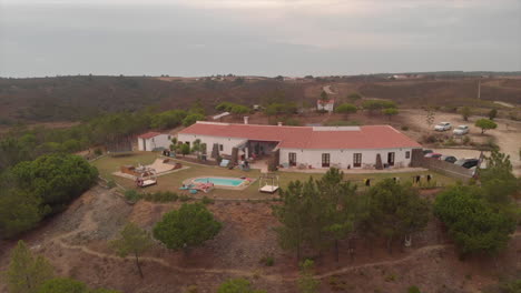 surfers chilling outside in a surf camp resort in algarve, portugal at dusk - aerial drone