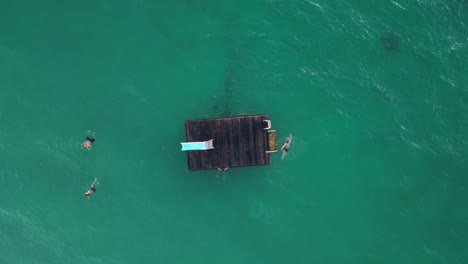 People-Jumping-From-Floating-Platform-In-Coogee-Beach,-Perth-City