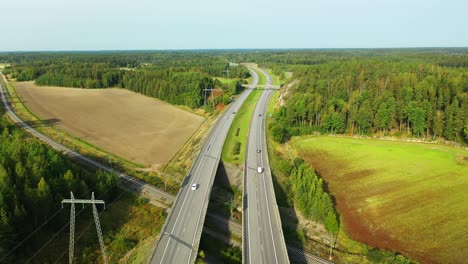 4k forward moving aerial view of 4-lane highway with cars and trucks passing both directions during hazy summer morning sunlight