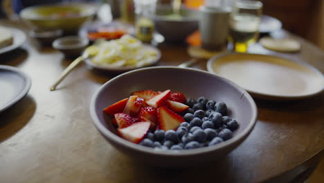 close-up view of a bowl of fruit with breakfast in the background