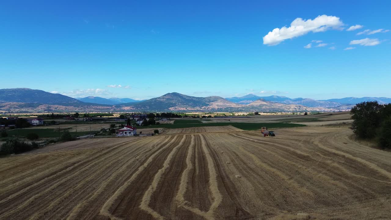 Hay baler tractor on the field compressing automatic farm machine agriculture rural, aerial drone