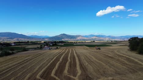 hay baler tractor on the field compressing automatic farm machine agriculture rural, aerial drone