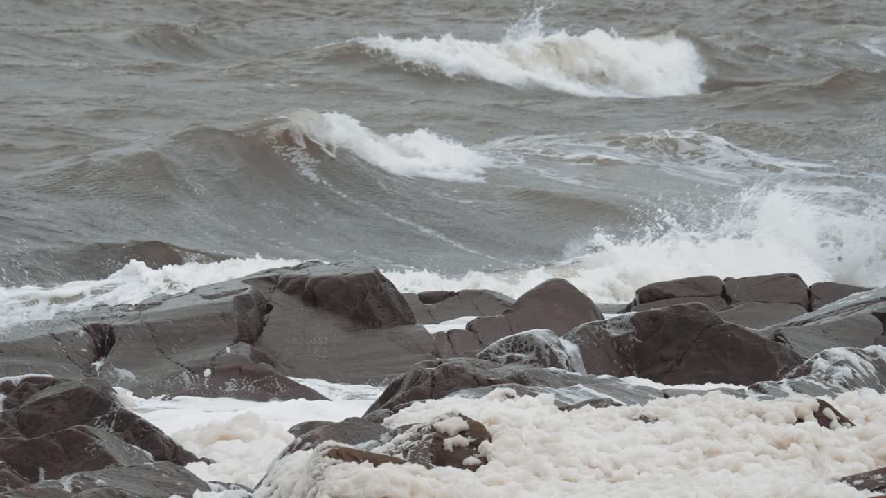 Slow motion waves curl in off the unfriendly seas of Canada's Hudson Bay and crash against the rocky shoreline