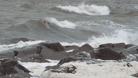 slow motion waves curl in off the unfriendly seas of canada's hudson bay and crash against the rocky shoreline