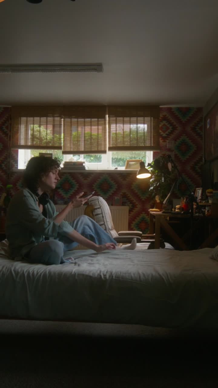 편안 한 침실 에서 전화 를 사용하는 여자