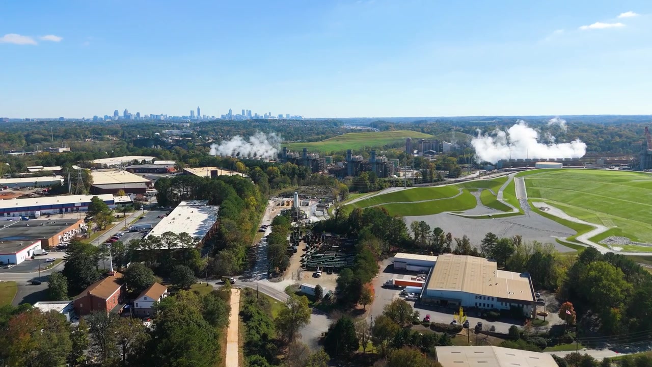 Aerial shot pushing in on a Georgia power plant and the Atlanta skyline.