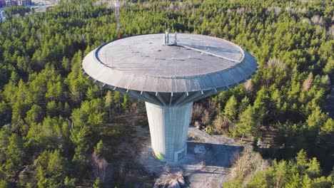 Water-tower-surrounded-by-trees.-Orbiting-drone-shot