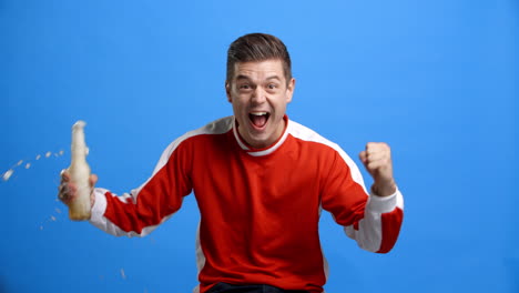 studio shot of sports fan with beer celebrating result