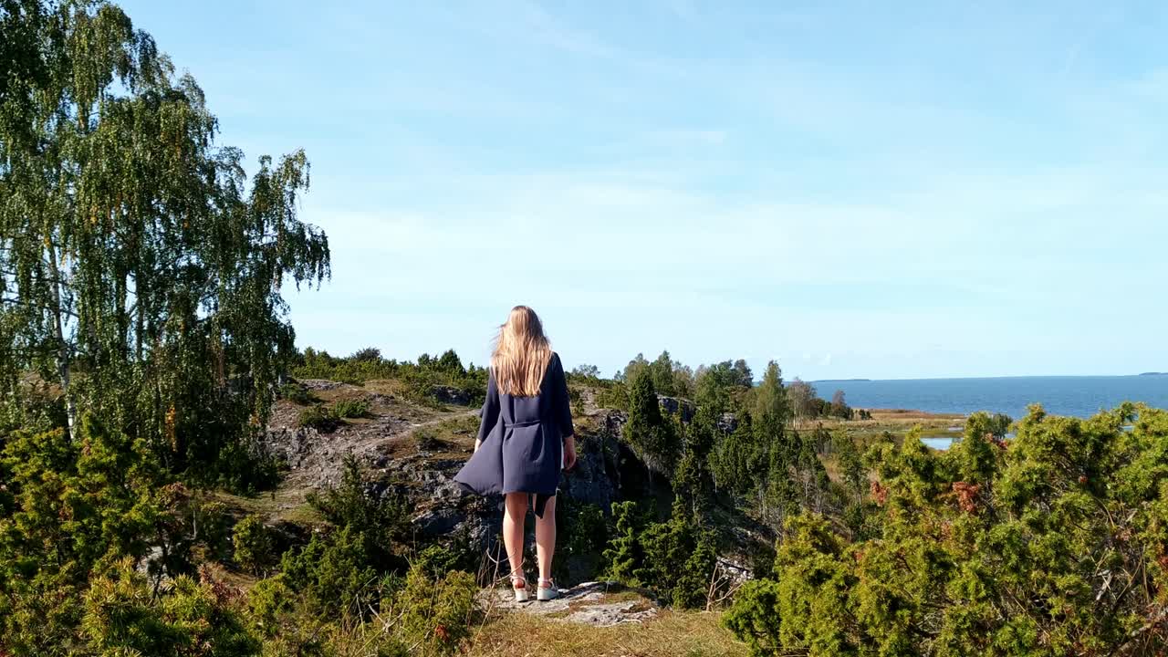 Solo traveller woman enjoying the view of Uugu Nature Park cliff, wide shot