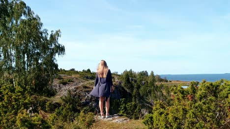 solo traveller woman enjoying the view of uugu nature park cliff, wide shot