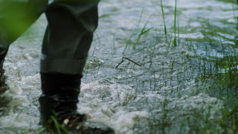 fly fisherman legs in waders walking through river while fishing in the colorado mountains in slow motion
