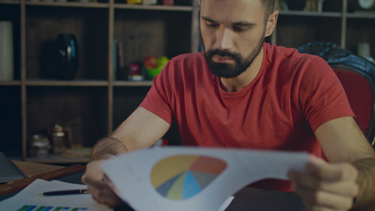 Uomo d'affari che legge documenti aziendali in ufficio. Ricercatore di mercato che analizza i documenti.