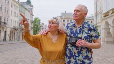 elderly old stylish family couple tourists man, woman on holidays vacation traveling on city street