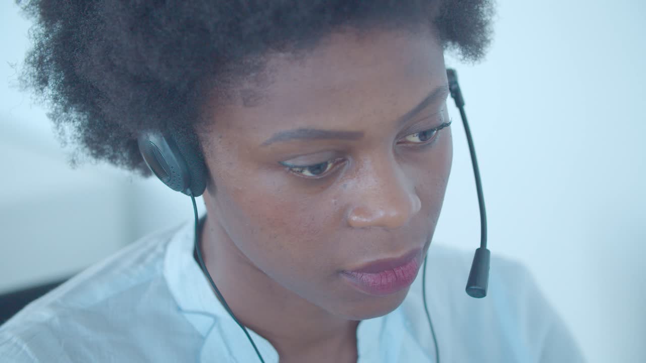 Focused African American employee in headset taking call