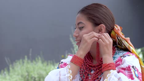 Clip-Cinematográfico-De-Una-Joven-Latina-Morena-Vestida-Con-El-Traje-Tradicional-Llamado-Cayambeñas-Poniéndose-Aretes-Y-Sonriendo