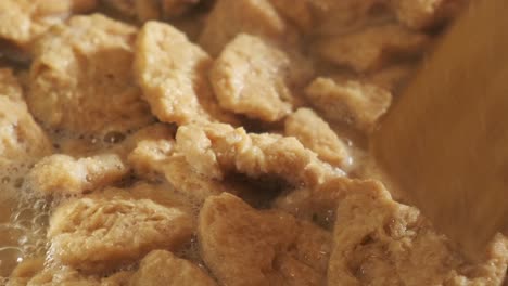 Close-up-view-of-cooking-vegan-TVP-Textured-Vegetable-Protein-in-a-pan,-in-slow-motion-4K