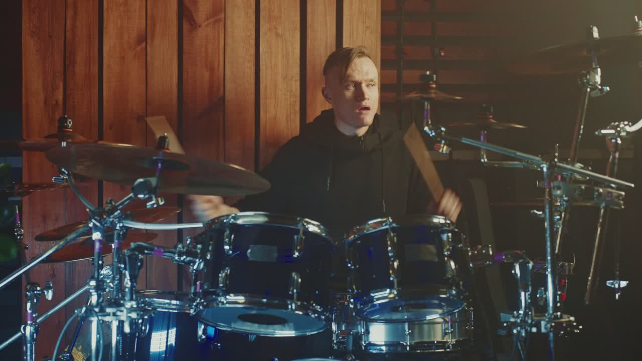 барабанщик играет на барабанах в музыкальной студии