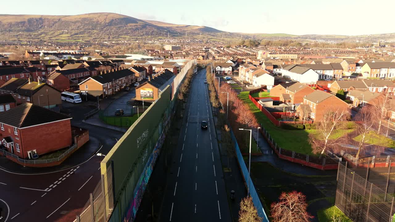 Wide static 4K 60FPS aerial video of the Belfast Peace Wall Interface in Belfast, Northern Ireland. The murals explore the politics of NI and worldwide. Produced with Rec709 color