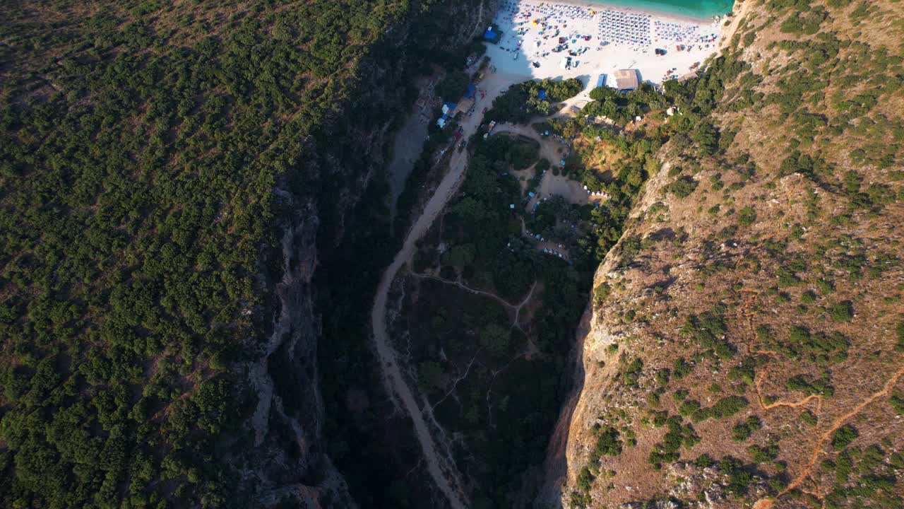un cañón rocoso revela una playa paradisíaca oculta a lo largo de la costa en gjipe, albania, un escape aislado.