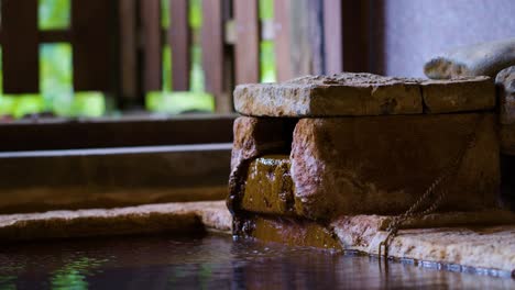 natural hot spring water flows into stone bath in kirishima, japan