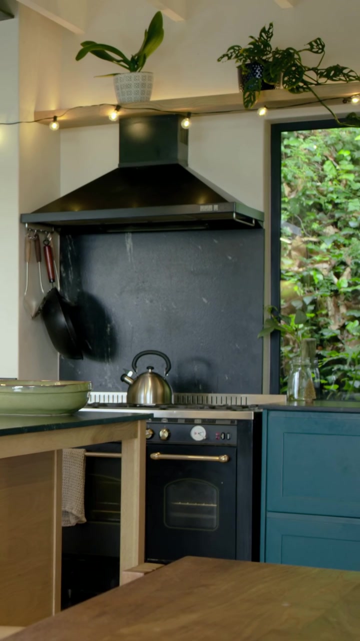 Video verticale: Pentole appese che oscillano sui ganci per la brezza in una cucina di casa, bollitore sul fornello