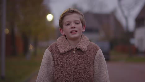 happy young boy talking towards camera