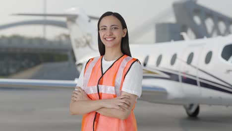 Happy-Indian-airport-ground-girl-staff-member-standing-crossed-hands